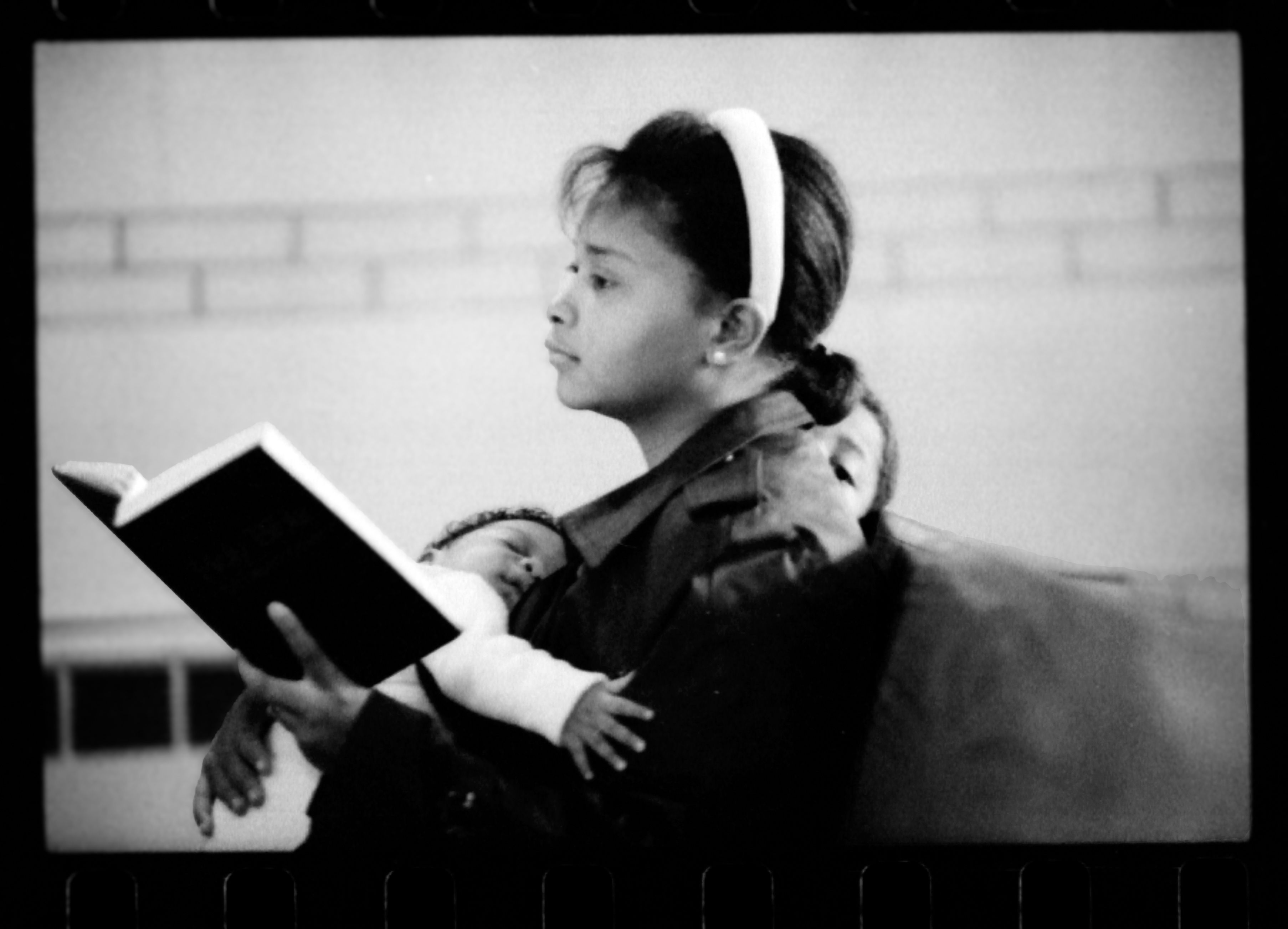 A mother holding two children while listening to a sermon at Roseland Christian Ministry Center in Chicago, 1989