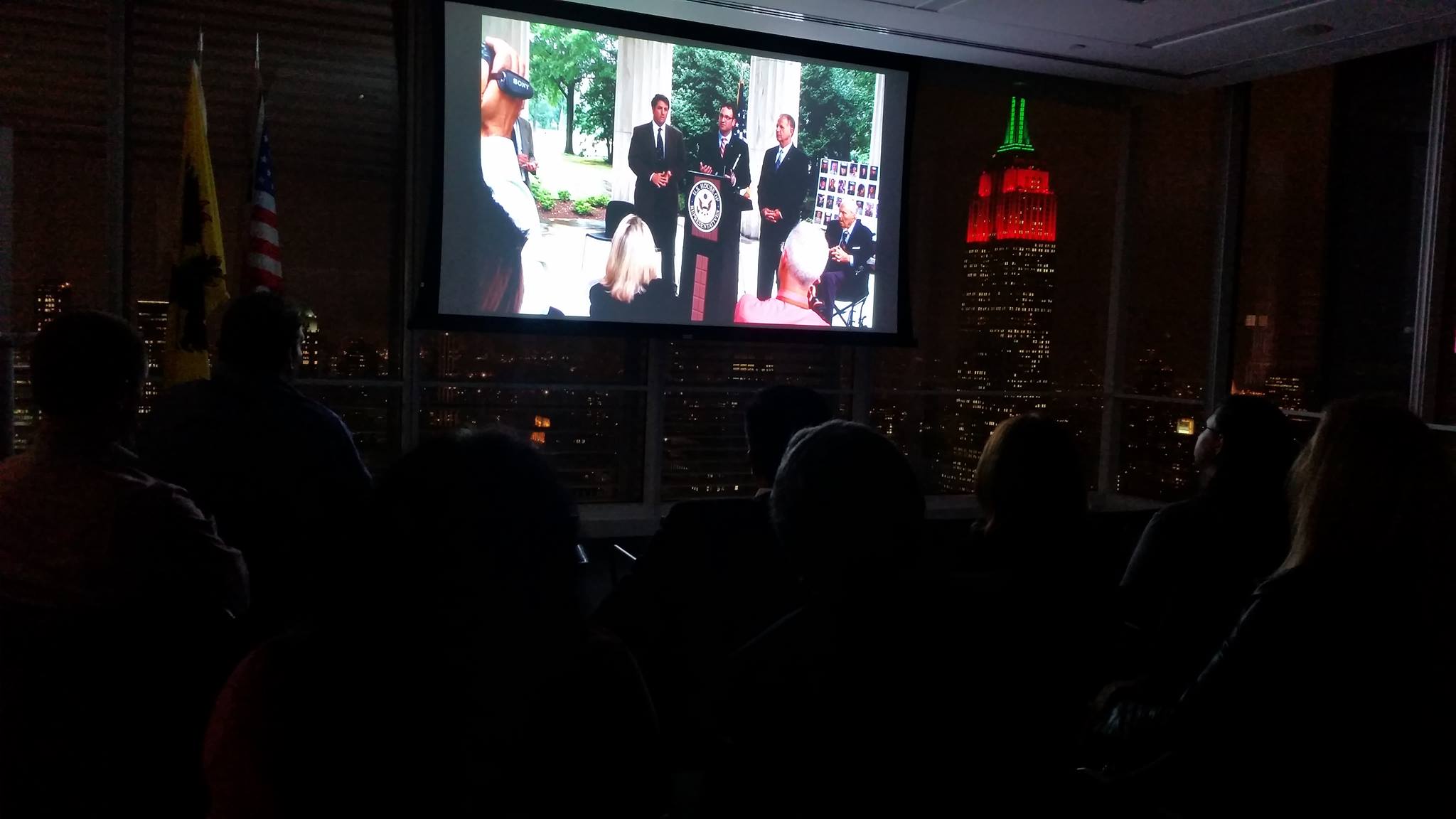 Pershing’s Last Patriot projected during a nighttime screening at Flanders House in New York City, with the Empire State Building visible beyond the windows
