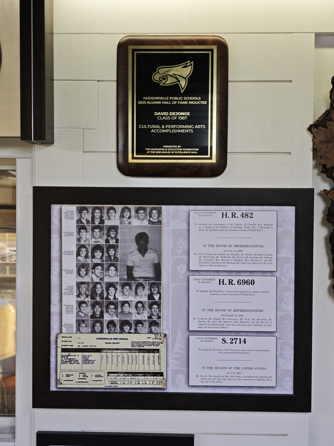David DeJonge's 2025 Hudsonville alumni Hall of Fame plaque above a display of his high-school record and early World War I bills