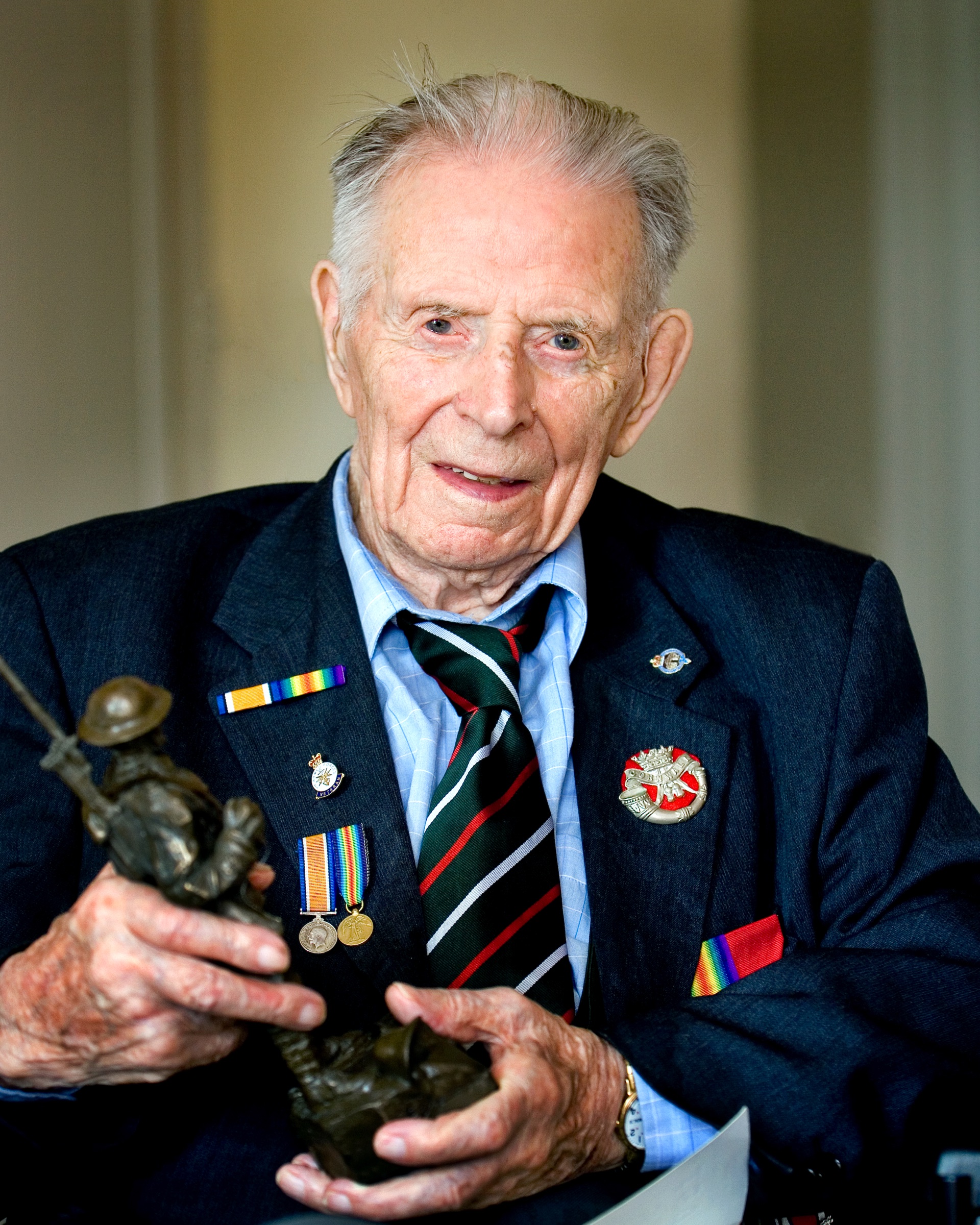 Portrait of Harry Patch holding a bronze First World War serviceman by David J. DeJonge