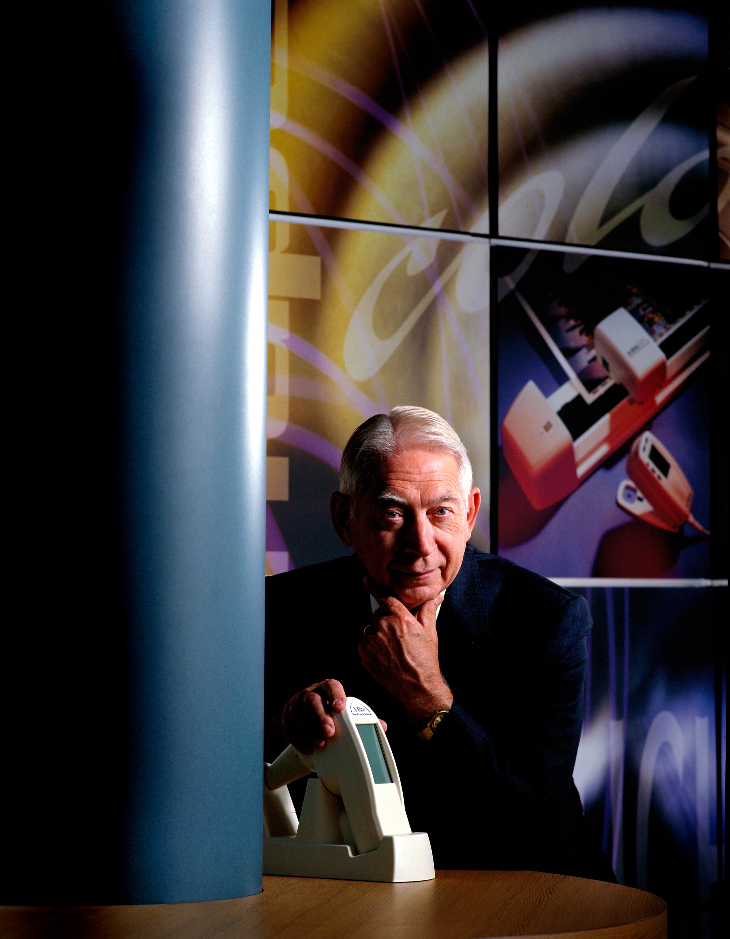 Portrait of X-Rite co-founder Darrell Ted Thompson posed with an X-Rite color-measurement instrument